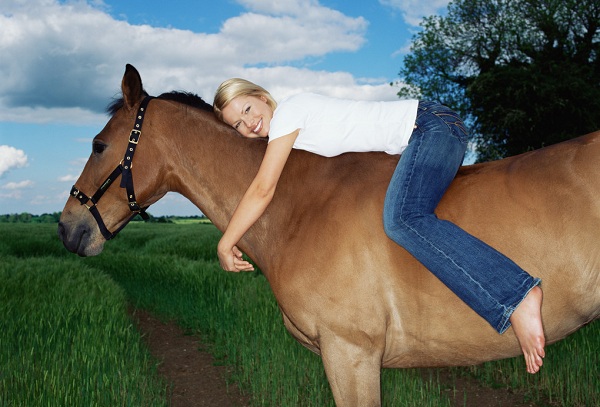 Smiling woman on horse --- Image by © Royalty-Free/Corbis